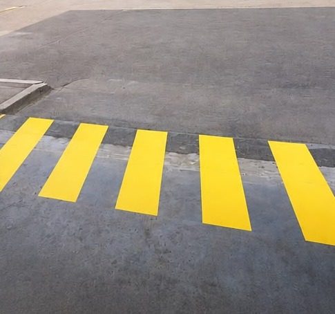 Passage piéton jaune tracé à l’intérieur d’un bâtiment industriel